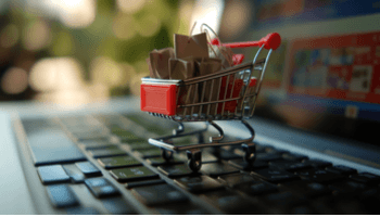 Anunciar-na-internet Imagem de um carrinho de compras sobre um computador, representando o conceito de anunciar na internet e gerar vendas online.